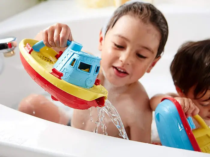 kids playing with toy boat in bath 