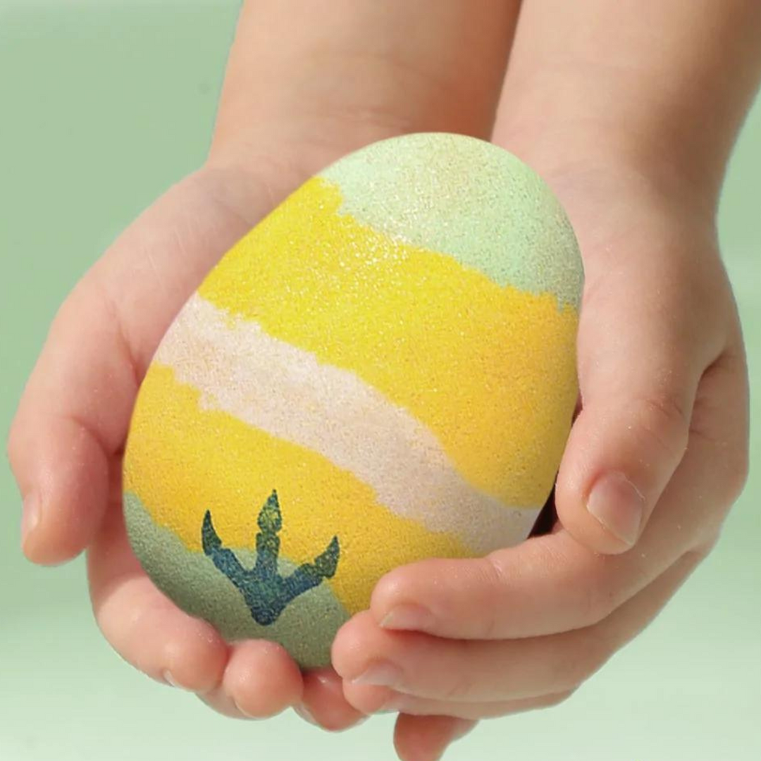 kid holding dinosaur bath bomb egg