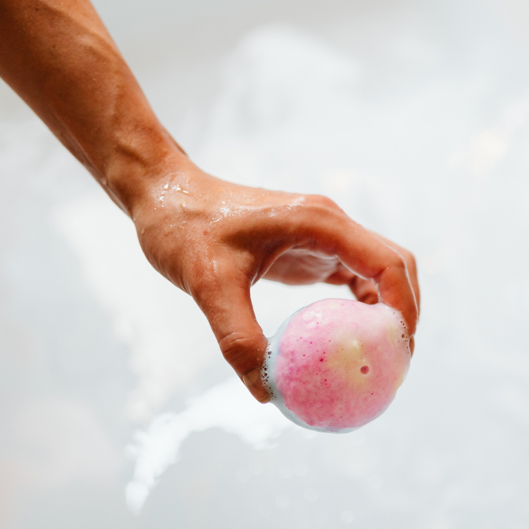 Womans hand putting bath bomb into water